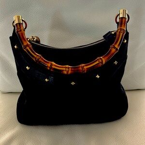 Genuine Gucci canvas with bamboo handle and leather trim.